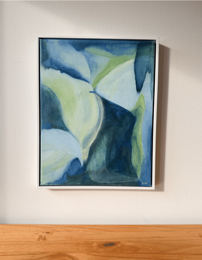 Framed abstract painting with blue and green tones on a white wall.